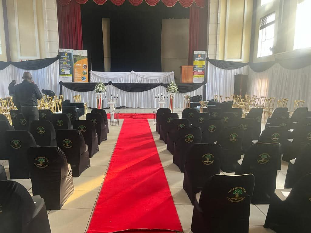A funeral venue prepared with covered chairs and a red carpet